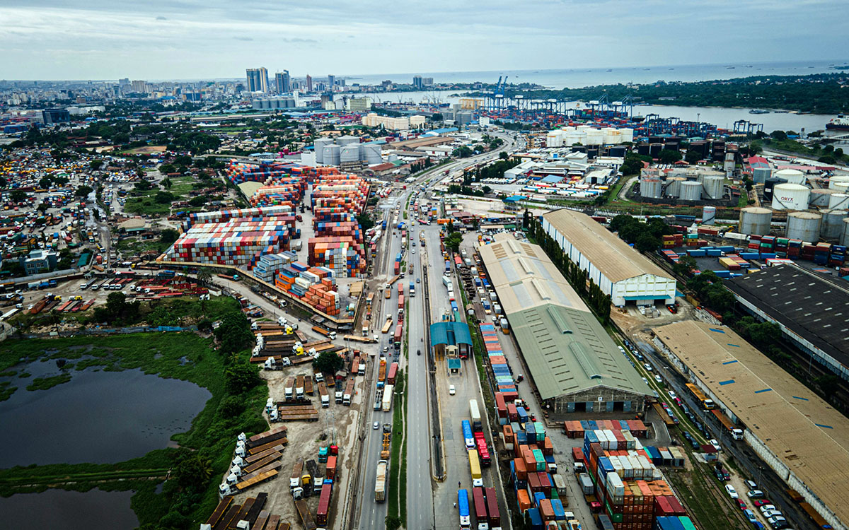A busy container terminal at the Port of Dar es Salaam with large cranes and shipping containers.